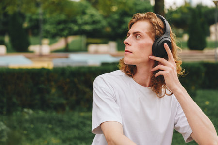 Listening to music while relaxing in a peaceful outdoor park settingの写真素材