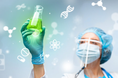 Scientist examines green liquid in flask during laboratory researchの写真素材