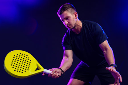 Player demonstrates skill in paddle sport during indoor competition at nightの写真素材