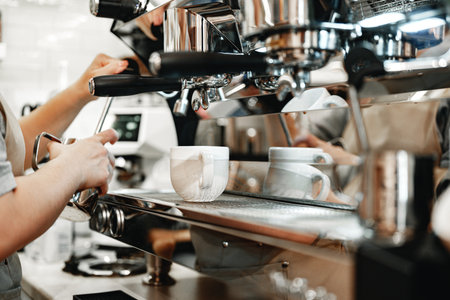Barista preparing espresso in a bustling cafe during morning hoursの写真素材