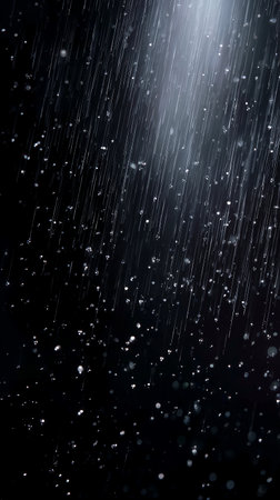 Raindrops falling against a dark background creating a serene atmosphereの素材
