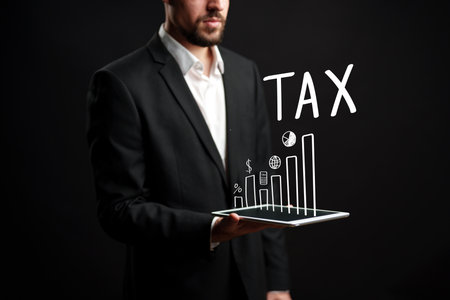Businessman presenting tax data with graphs and charts on a digital tabletの写真素材
