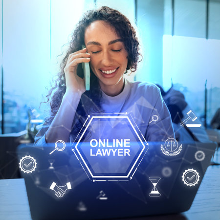 Professional woman on the phone while working on a laptop with symbols of online law servicesの写真素材
