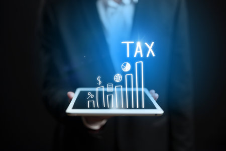 Businessman using tablet to analyze tax data in a professional settingの写真素材