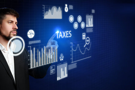 Businessman interacts with digital tax data on touchscreen display in modern office environmentの写真素材