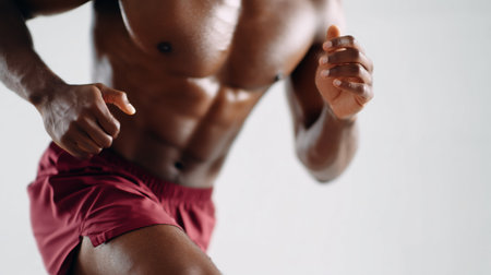 Runner in motion with strong physique and focused expression during workout sessionの素材