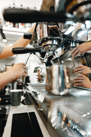 Barista making espresso with a professional machine in a busy coffee shopの写真素材
