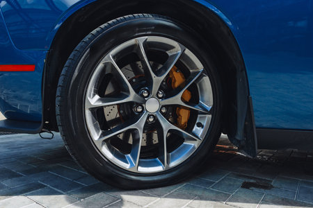 Sleek blue sports car wheel with shiny alloy rims and detailed brake calipersの写真素材