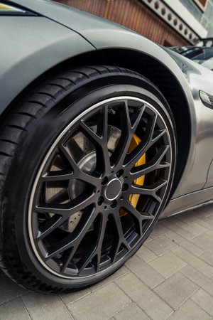 Close-up view of sleek car wheel with striking design and details in urban setting