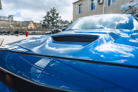 Close-up view of a sleek blue sports car hood with a stylish air intakeの写真素材