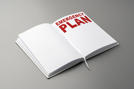 Emergency plan written in a notebook with clear text on a gray backgroundの写真素材