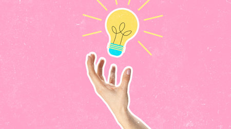 Creative hand reaching for a light bulb against a pink background