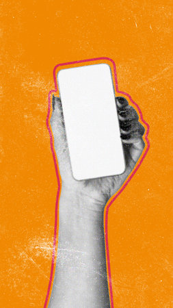 Hand holding a blank smartphone against an orange background in a creative displayの写真素材