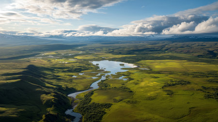 Birds eye view of a green landscape with rivers and hills under a blue skyの素材
