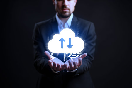 Man holds cloud icon with arrows in dark space showing data management at night