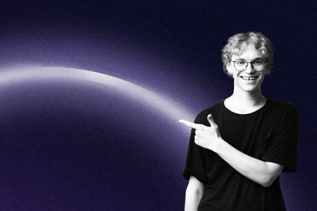 Person points to a bright curve in a dark background in a simple studio setting