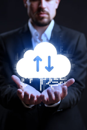 Man holding cloud symbol showing upload and download arrows in a dark setting
