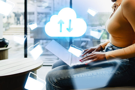 Person uses laptop for cloud storage in modern workspace during the dayの写真素材