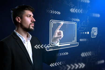 Man interacts with holographic laptop display in modern tech environment