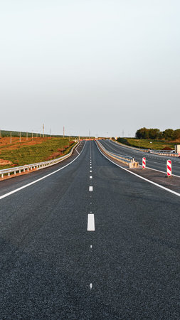 Highway stretching far with no visible cars on a clear day in an open landscape