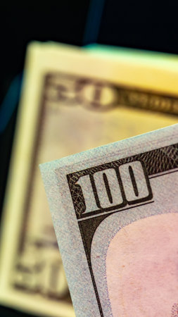 Close up of a hundred dollar bill with a fifty dollar bill in the backgroundの写真素材