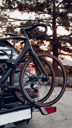 Bicycles loaded on a car ready for a trip after sunset in a forest areaの写真素材