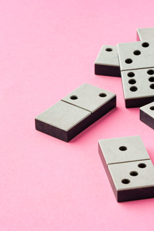 Playing dominoes on a pink background with pieces arranged in different positionsの写真素材