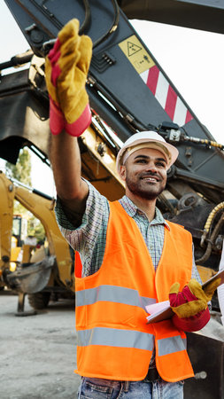 Construction worker signals with a smile at a building site in the afternoon