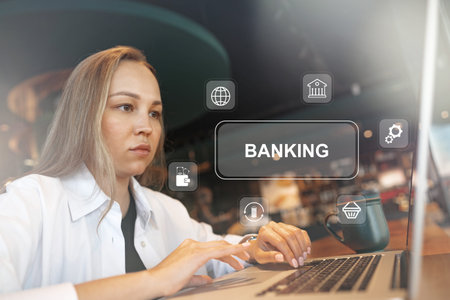 Young woman using laptop for banking tasks in a modern cafe setting during daytimeの写真素材
