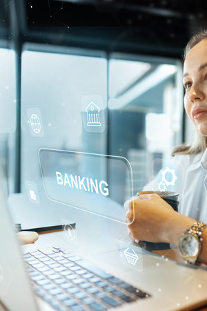 User reviews banking invoice payment while using a laptop in a modern workspace