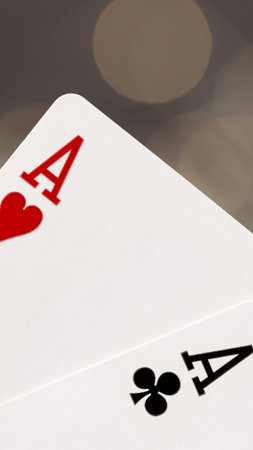Two playing cards rest on a table during a card game at a local gathering