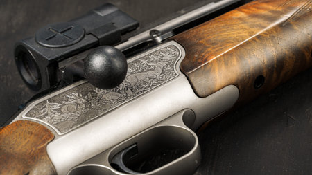 Detailed view of a hunting rifle with wood finish and scope in a close-up setting