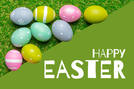 Colorful eggs on green grass wishing happy Easter for spring celebrations and activitiesの写真素材