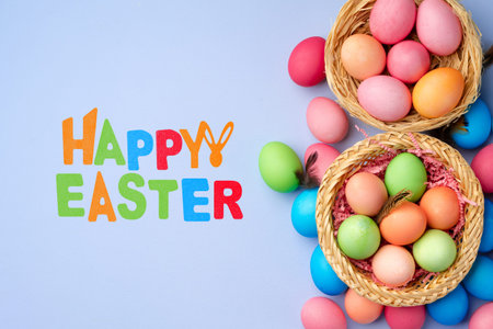 Colorful baskets with eggs and happy Easter greeting on a blue background