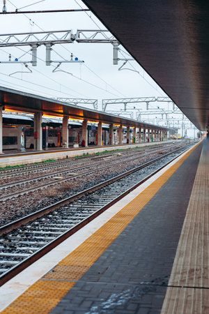 Train station platform with empty tracks during early morning hours in a city