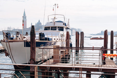 Boat docked at waterfront with buildings in the background during daytime in a coastal area
