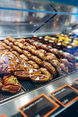Pastries on display at a bakery showing various types of desserts in a busy shop
