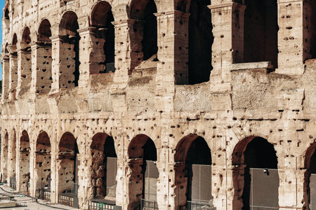Colosseum stands in Rome during a clear day with tourists around and history in the air