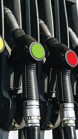 Different fuel dispensers lined up at a gas station showing various colors and types