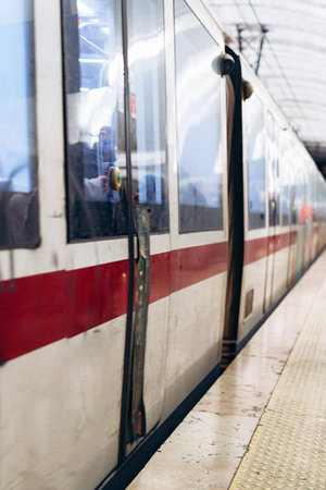 Train stops at platform for passengers to board and disembark during busy travel time