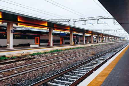 Train station with several trains and empty platforms during the day in a busy city