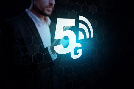 Person using device with 5G internet symbol in a dark setting at a technology event