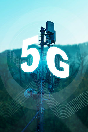 5G internet tower stands tall against a clear sky and green hills during the day