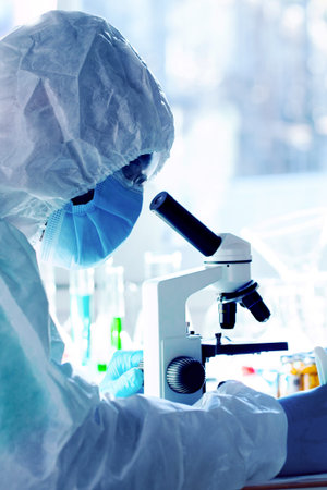 Scientist conducts research with a microscope in a laboratory during daylight hours