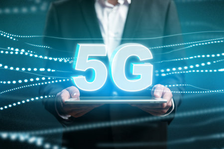 Person holding device showing 5G text with digital lines in the background