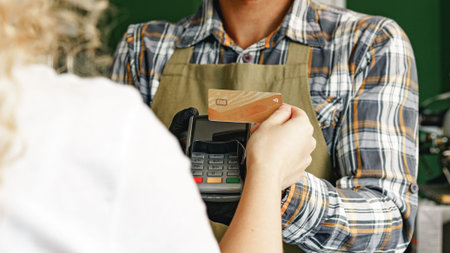 Customer pays with card at a store during a sunny afternoon