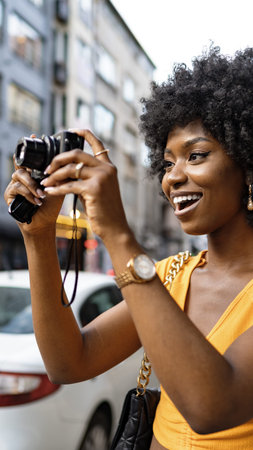 Woman takes a picture with a camera on a city street during the day