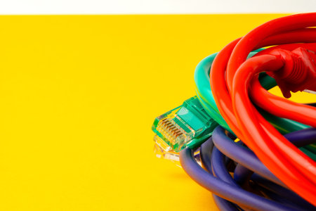 Colorful cables arranged on a yellow background with one connector visible on the side