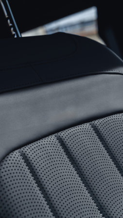 Close up view of a car seat showing leather texture and stitching patterns