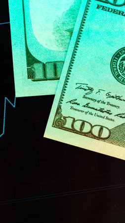 Dollar bills placed near a financial chart showing a rising trend in the market over time